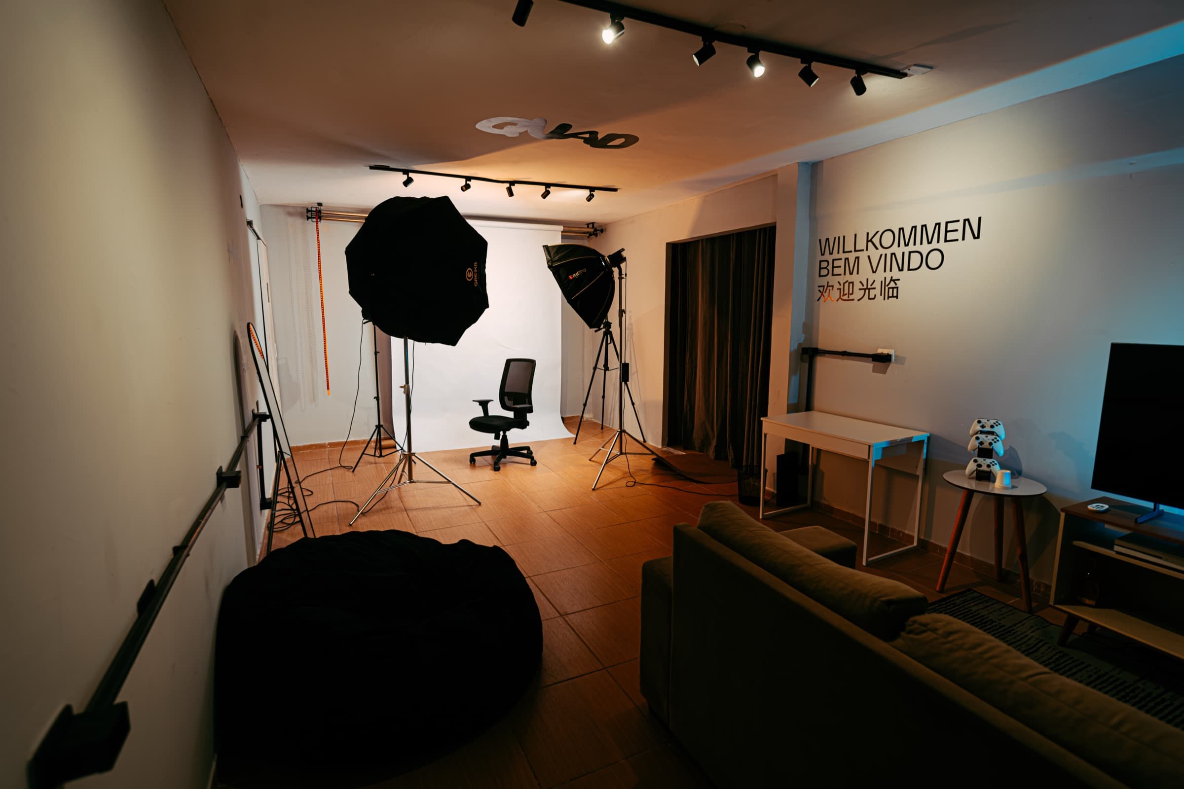 Vista geral do estúdio QUAD SPACE, com softboxes, fundo infinito e a sala de apoio ao fundo